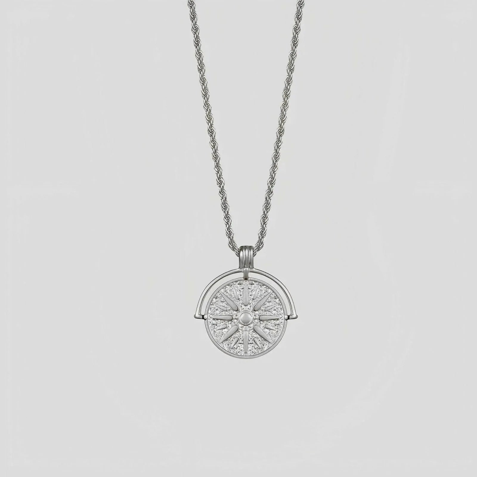 Circular stainless steel pendant necklace with sunflower embossing and star designs on adjustable hemp flower chain