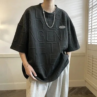 Grey men's loose T-shirt with a raised black three-dimensional retro letter design on the chest.