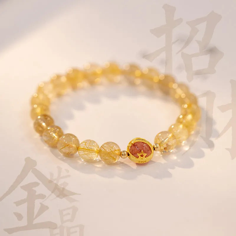 Citrine and gold rutilated quartz stretch bracelet with diamond-cut beads on an elastic band.