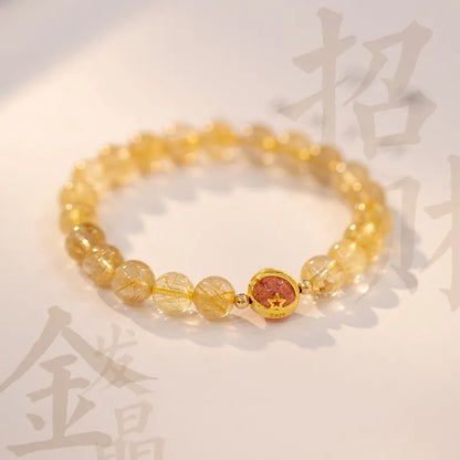 Citrine and gold rutilated quartz stretch bracelet with diamond-cut beads on an elastic band.