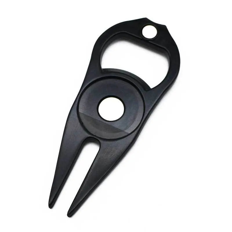A black zinc alloy golf ball yoke tool with a bottle opener and a separate ball coin on a putting green.