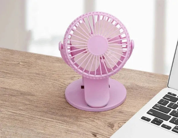 White USB rechargeable clip fan with plastic blades attached to a stroller handle.