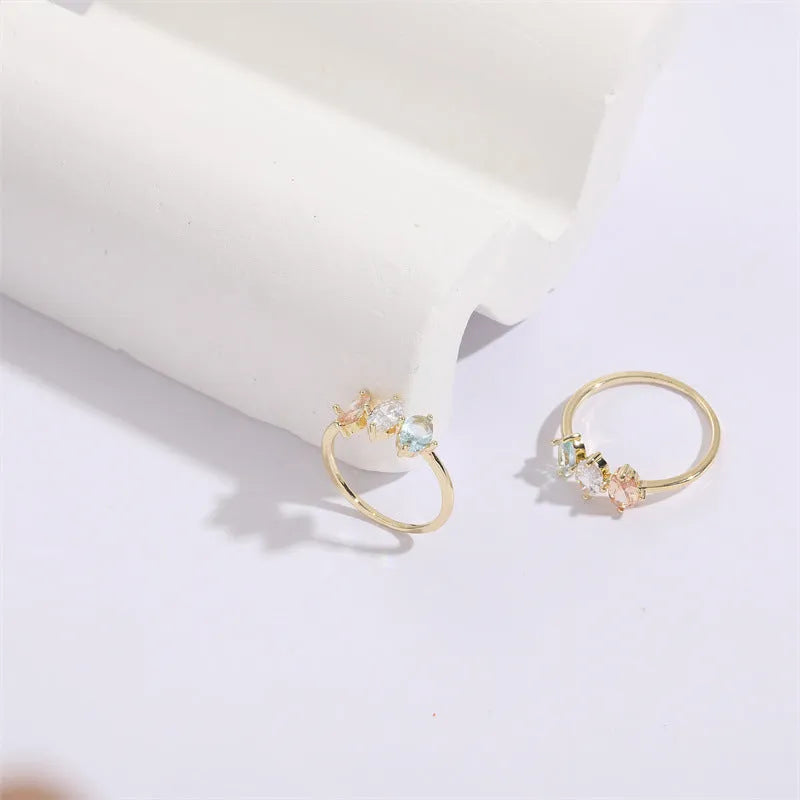 Geometric women's copper ring with triangle design, tricolour zircon stones, and birthstone in electroplated gold finish