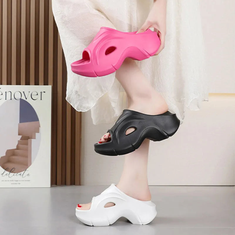 Women's thick-soled EVA foam beach slippers in rose red colour on a sandy background.