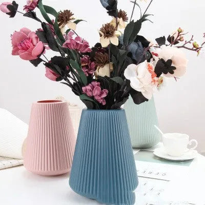 Melamine plastic decorative vase in blue colour measuring 16cm by 20cm on wooden desk
