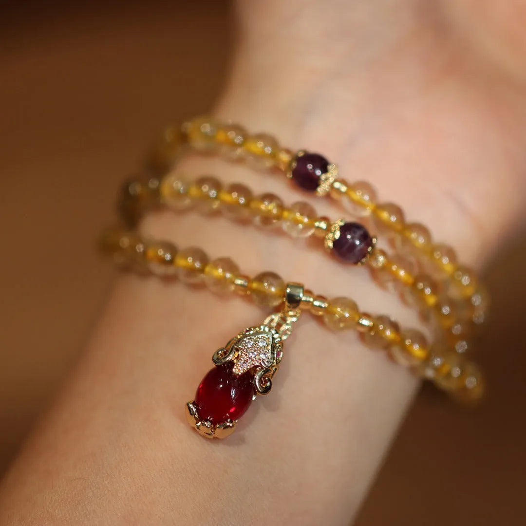 Close-up of a natural gold rutilated quartz bracelet with a Chinese style three-circle design.