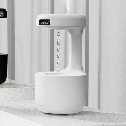 White columnar anti-gravity humidifier with LED clock display on a wooden desk