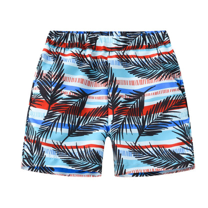 Colourful printed beach shorts with elastic waistband showing tropical patterns including coconut trees and pineapples