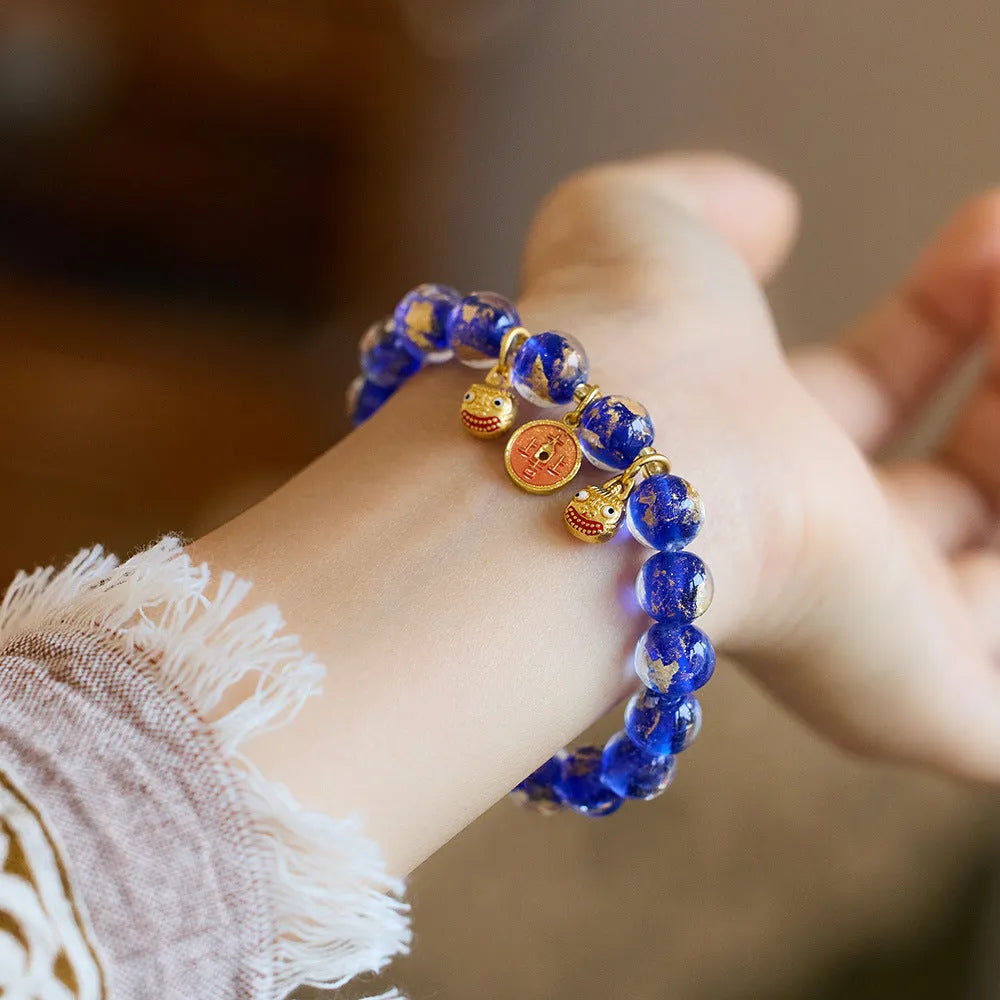 Handmade national style bracelet with coloured glaze swallowing gold beast charm on beaded band.