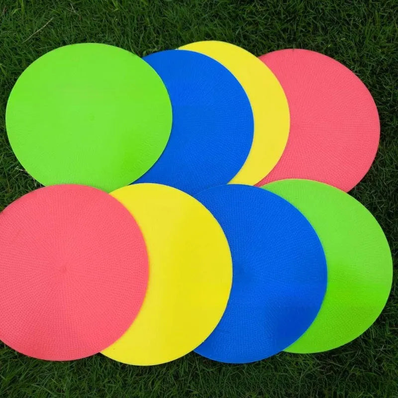 Soft yellow TPE football landmark pad disc on grass, 23 cm diameter.