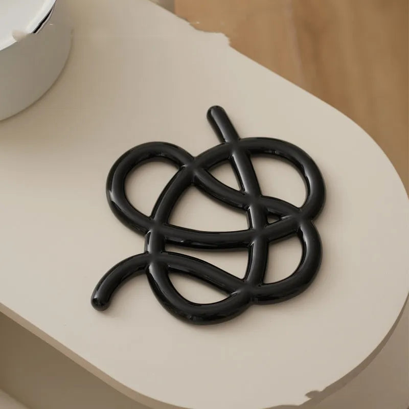 Ceramic heat-proof mat in irregular shape on dining table, protecting surface from hot pot
