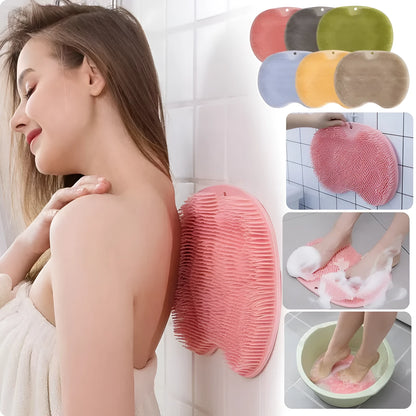 Orange non-slip massage bath brush with silicone bristles and suction cup base on shower floor