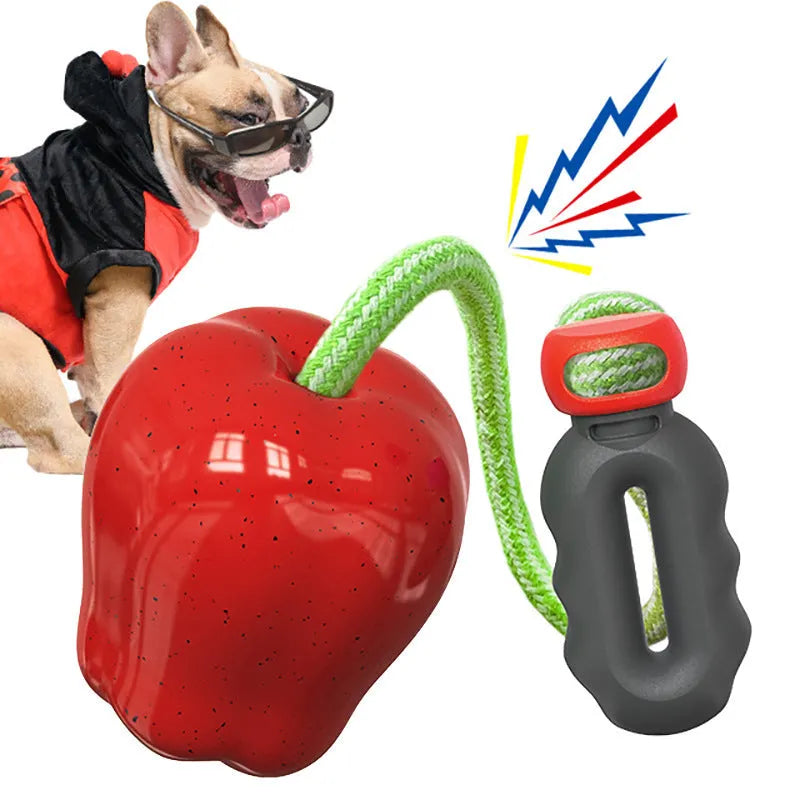 Green and red plastic molar-shaped dog ball with a hollow centre for treats, designed for outdoor fetch.