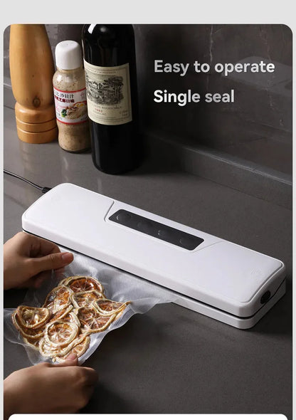 White automatic vacuum sealer on a kitchen counter, showing compact design with one-touch button for food preservation.