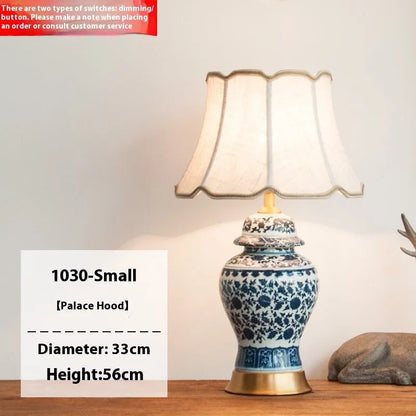 Traditional blue and white Chinese ceramic table lamp with a cloth shade on a bedside table.