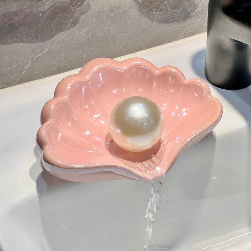 Plastic shell soap dish in pearl white, dimensions 12x9x5.5cm, on a bathroom counter