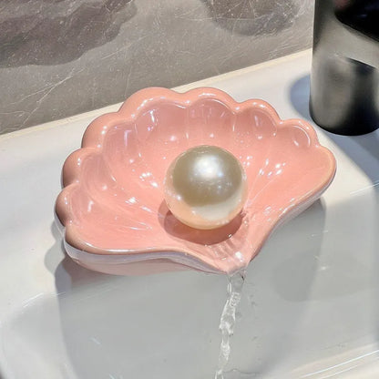 Plastic shell soap dish in pearl white, dimensions 12x9x5.5cm, on a bathroom counter