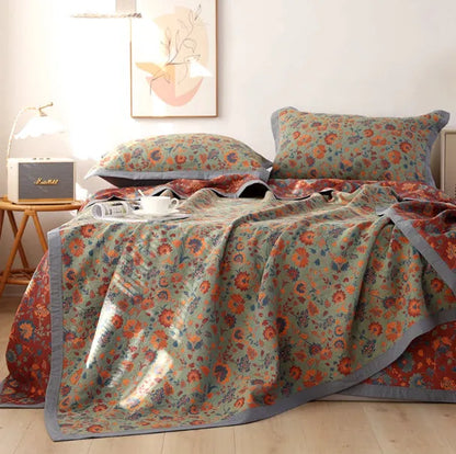 Three-piece cotton gauze bed set with floral print, showing blanket and pillowcases on a bed.