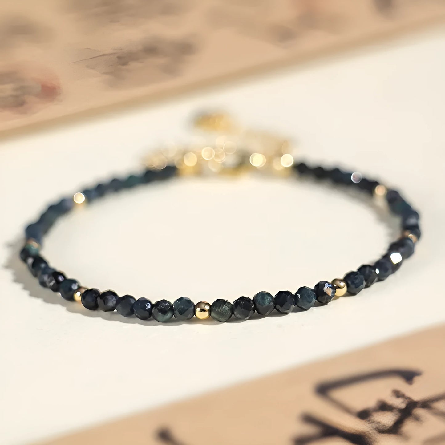 Close-up of a blue tourmaline beaded bracelet with 3mm stones and spacer beads on a wrist.