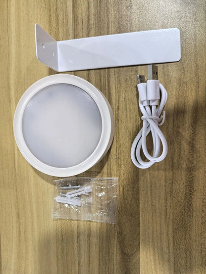 Black magnetic LED painting lamp with remote control on a white wall.