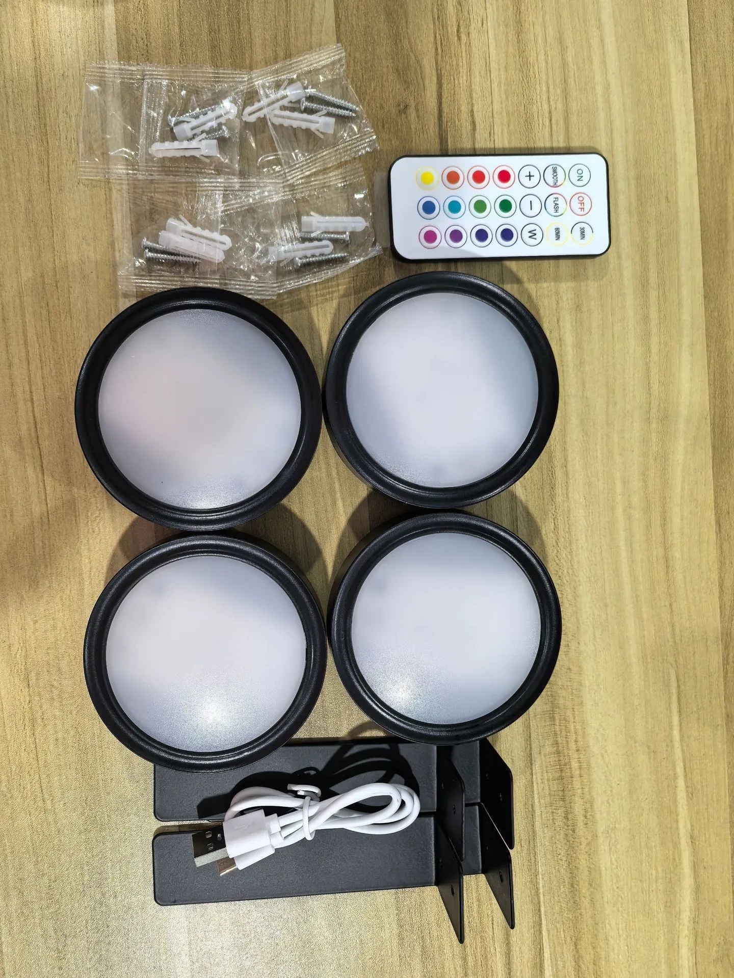 Black magnetic LED painting lamp with remote control on a white wall.