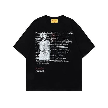 Man wearing a black loose-fit pure cotton t-shirt with a white letter print and short raglan sleeves.