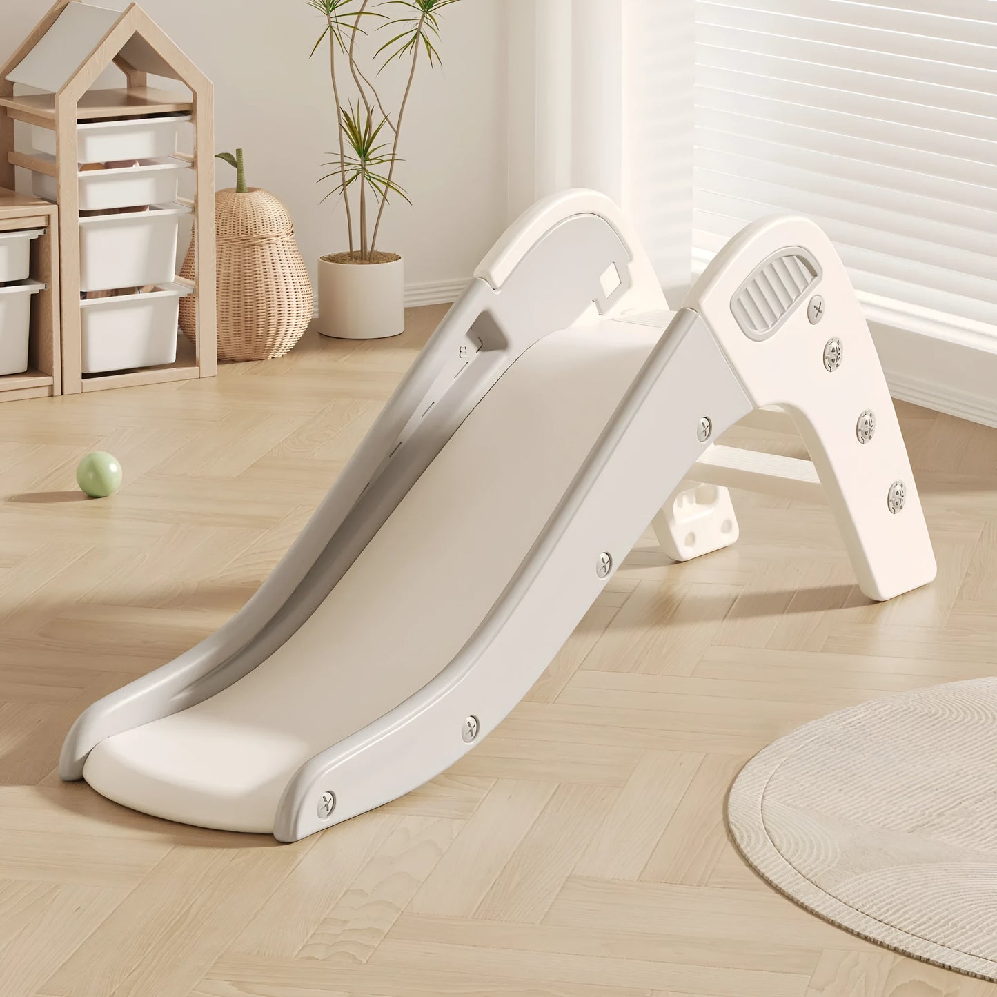 Small blue plastic baby slide for toddlers in a garden setting.