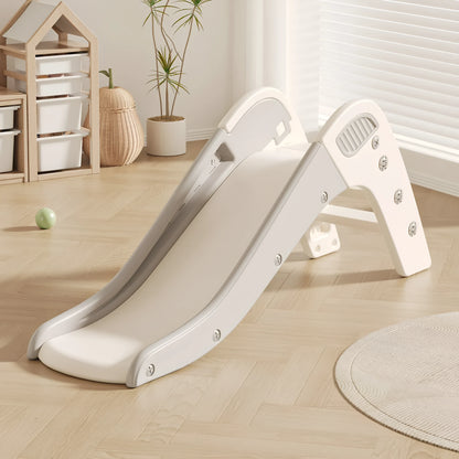 Small blue plastic baby slide for toddlers in a garden setting.