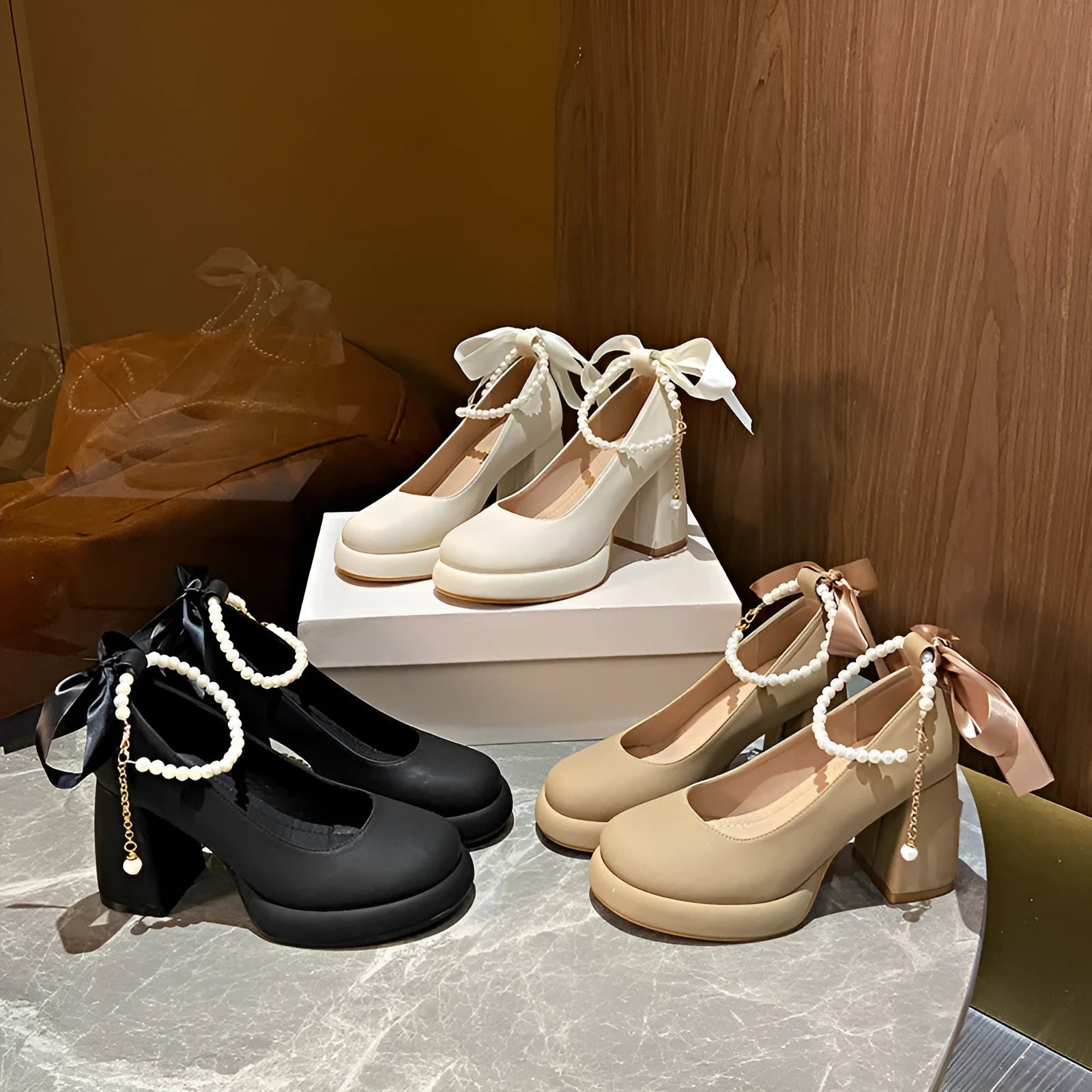 Women's beige Mary Jane shoes with chunky heel, ankle strap, pearl buckle, and round toe on a rubber sole.