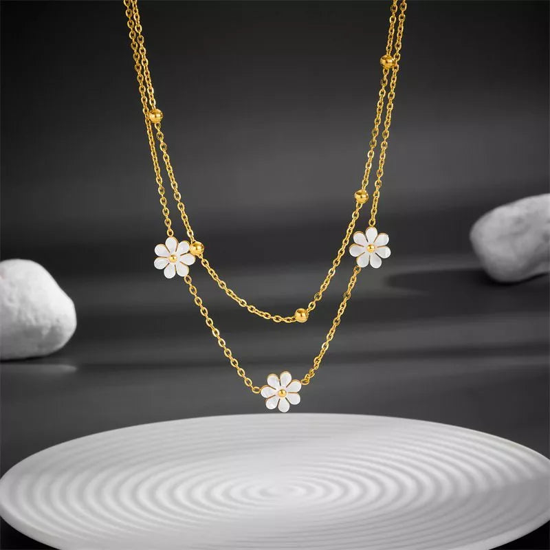 Stainless steel daisy flower jewelry set with necklace, bracelet, and earrings in electroplated gold finish