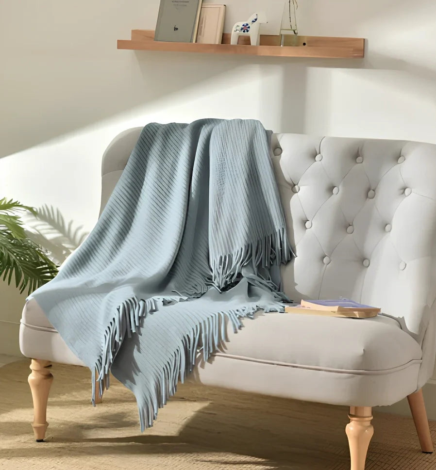 130x150cm knitted acrylic blanket with 10cm fringe detailing in beige colour draped over sofa