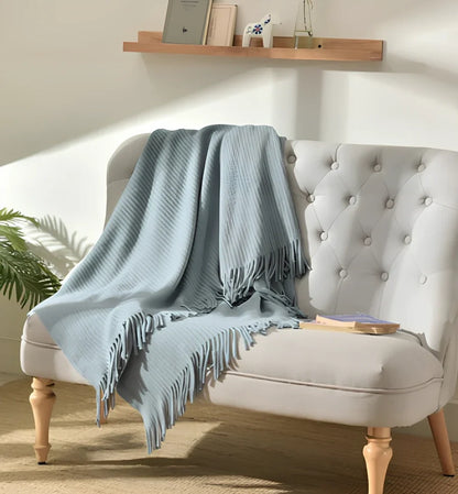 130x150cm knitted acrylic blanket with 10cm fringe detailing in beige colour draped over sofa