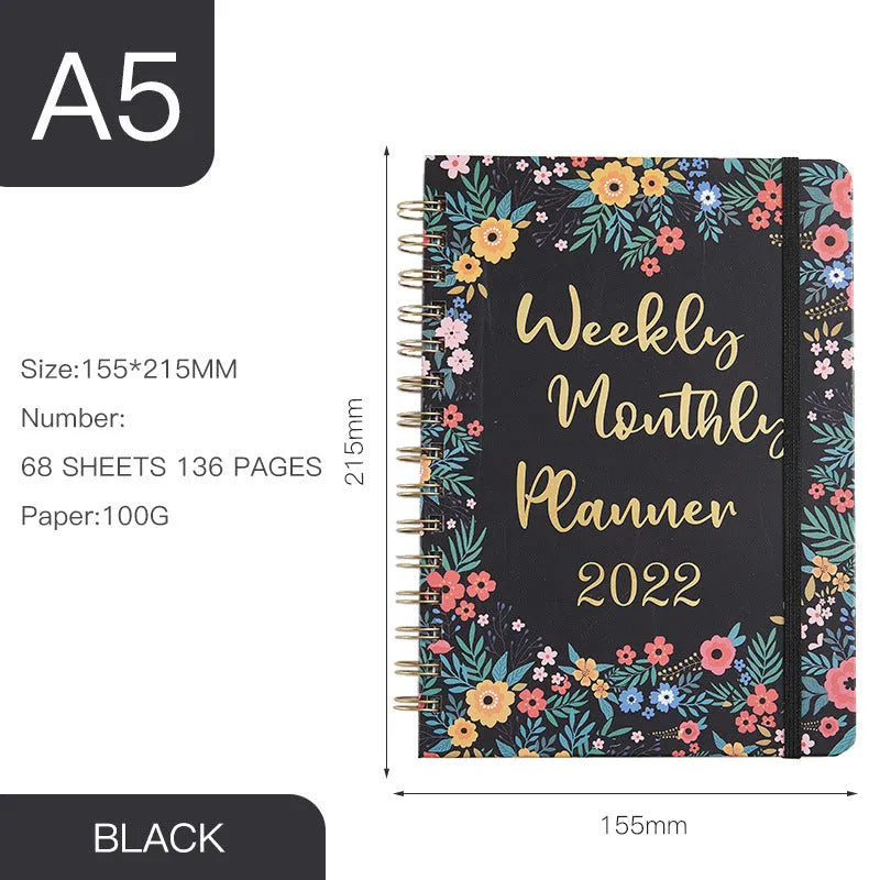 A5 spiral coil notebook open showing annual calendar pages and spiral binding