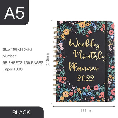 A5 spiral coil notebook open showing annual calendar pages and spiral binding