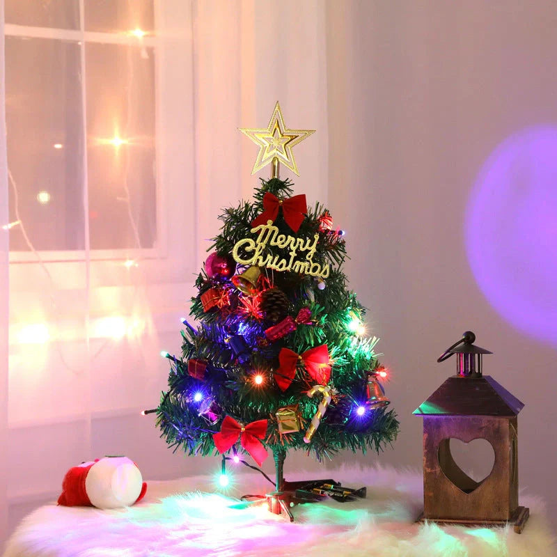 Mini Christmas tree with multi-color LED lights and festive accessories on a desktop