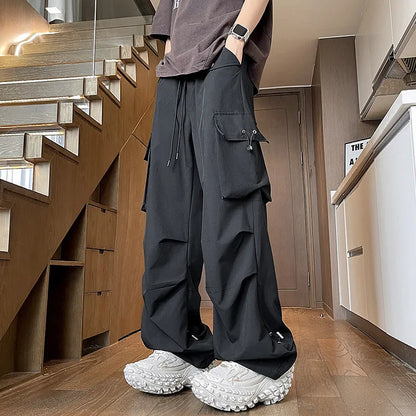Women's plus-size waterproof trousers in grey, showing straight-leg cut and drawstring waist.