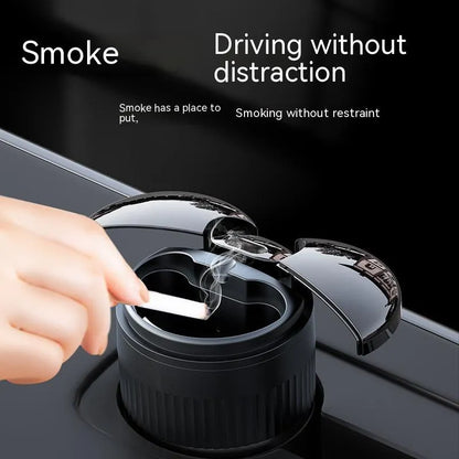 Compact black metal car ashtray with automatic lid on a car console