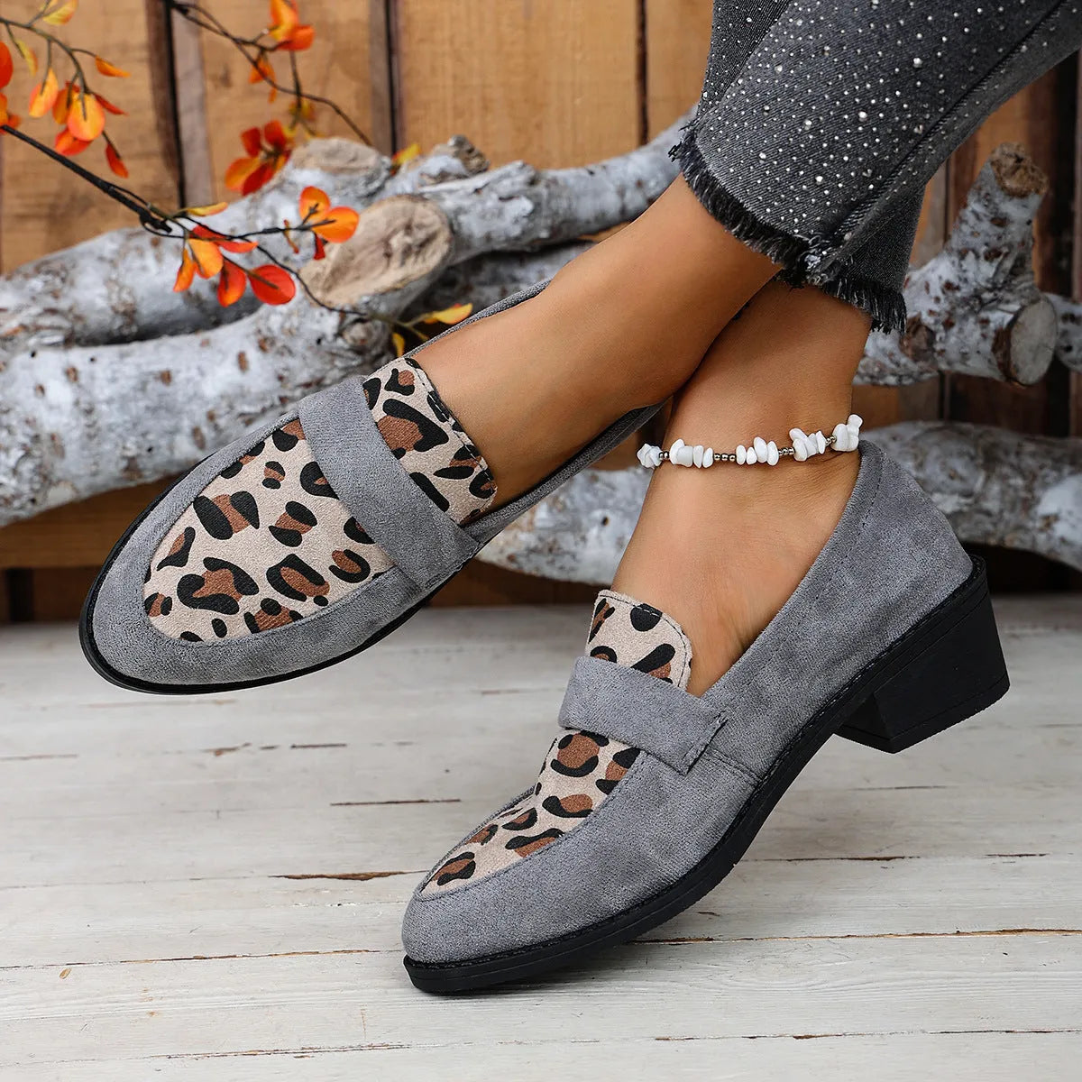 Leopard print slip-on suede pump shoe with chunky mid heel and pointed toe on a rubber sole.