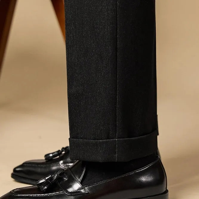 Men's black genuine leather tassel loafers with a rubber sole, shown from a side angle.