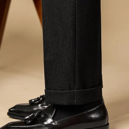 Men's black genuine leather tassel loafers with a rubber sole, shown from a side angle.