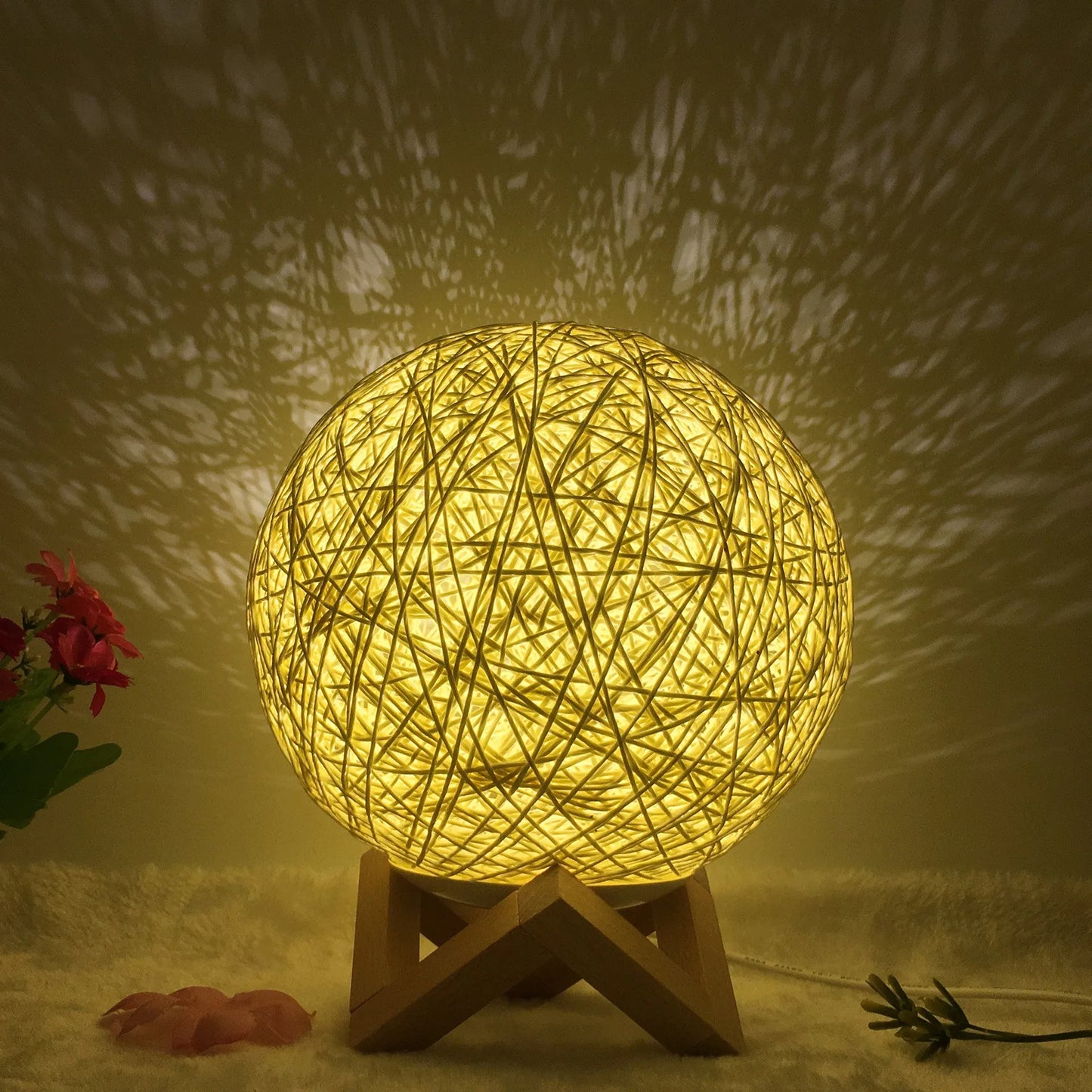 Spherical hand-knitted rattan table lamp with remote control on a wooden desk