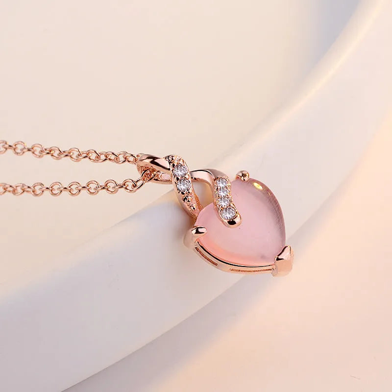Women's heart-shaped pink crystal pendant necklace with rose gold finish and cross chain