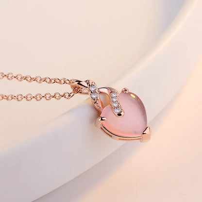 Women's heart-shaped pink crystal pendant necklace with rose gold finish and cross chain
