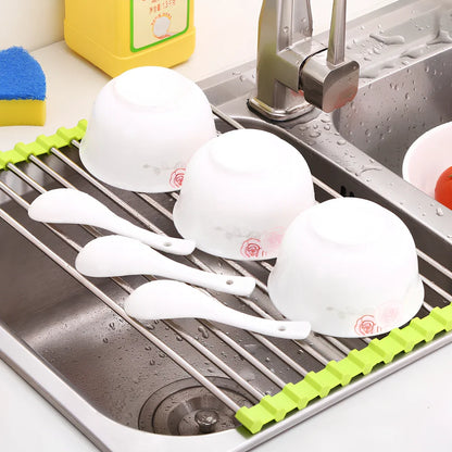 Black folding stainless steel sink drain rack with silicone edges, shown both unfolded for drying and folded for storage