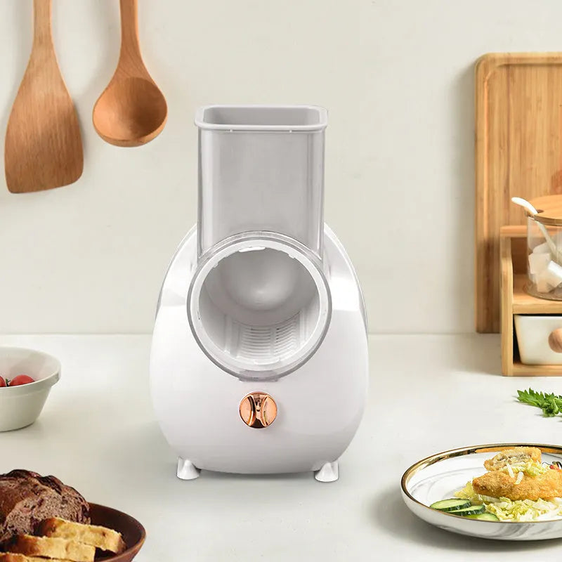 White electric vegetable slicer with feeding port and suction base on kitchen counter