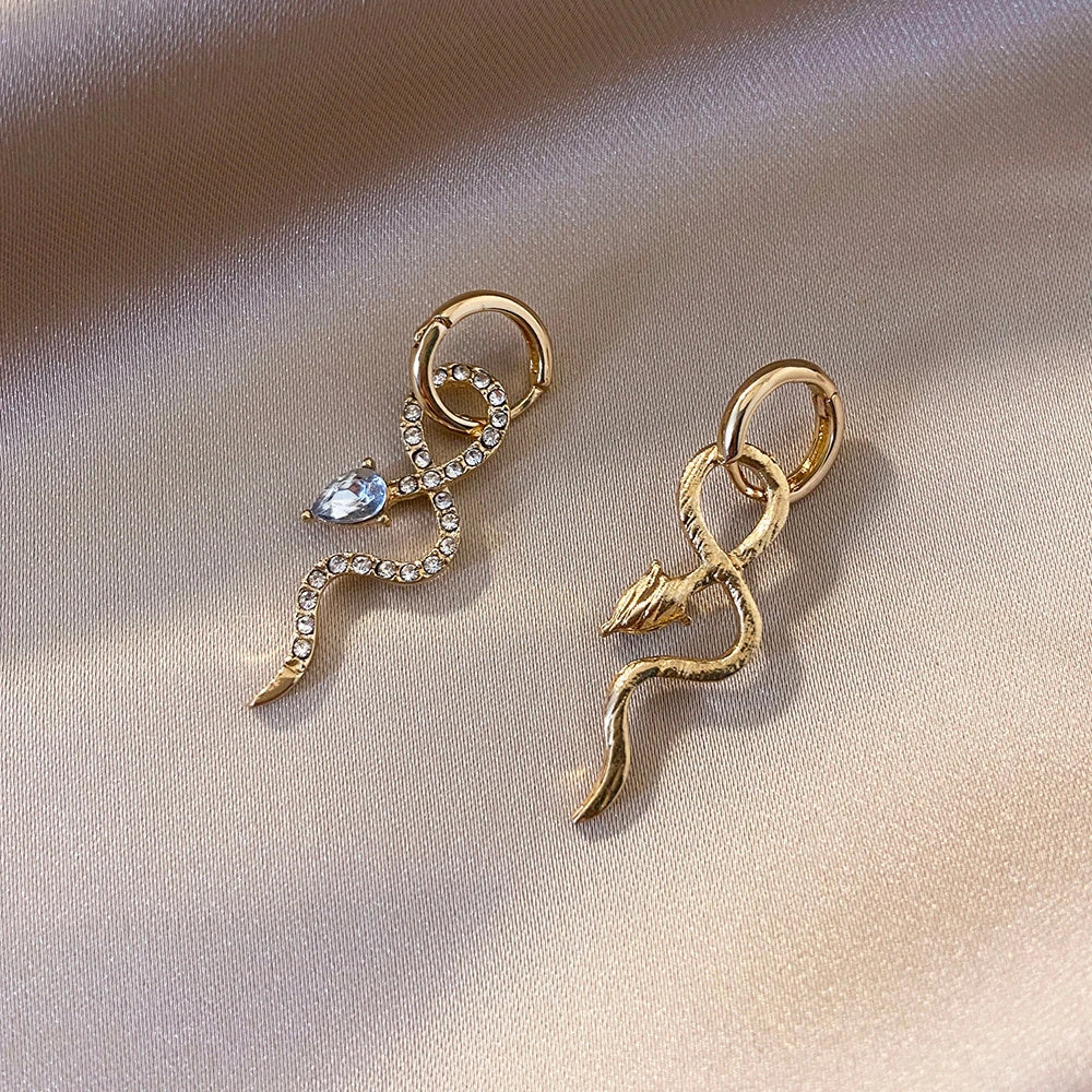 Pair of golden snake-inspired dangle earrings with a captivating and elegant design