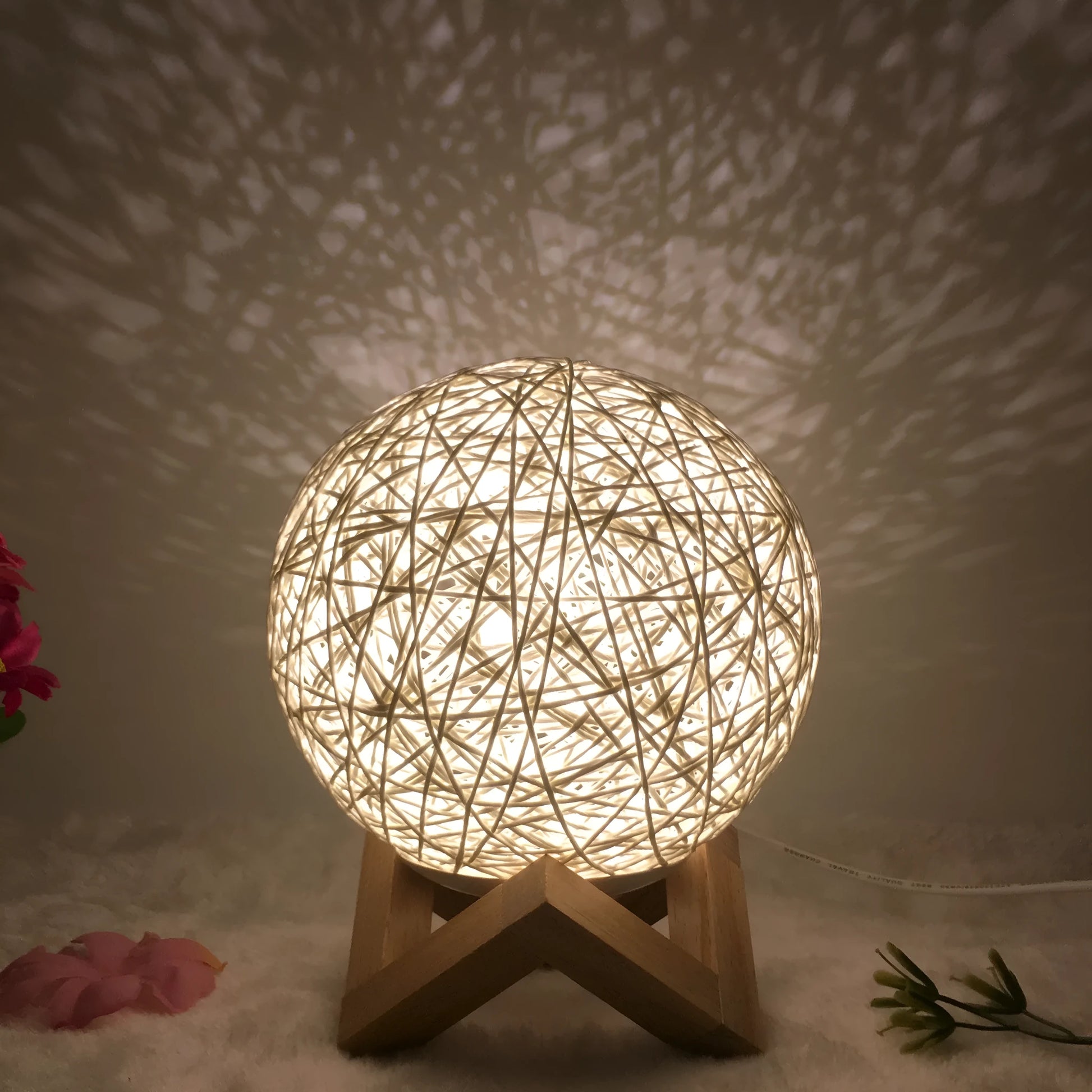 Spherical hand-knitted rattan table lamp with remote control on a wooden desk