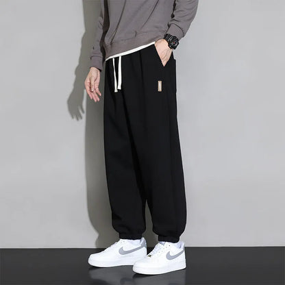 Men's loose gray casual sports trousers with drawstring waist on a hanger