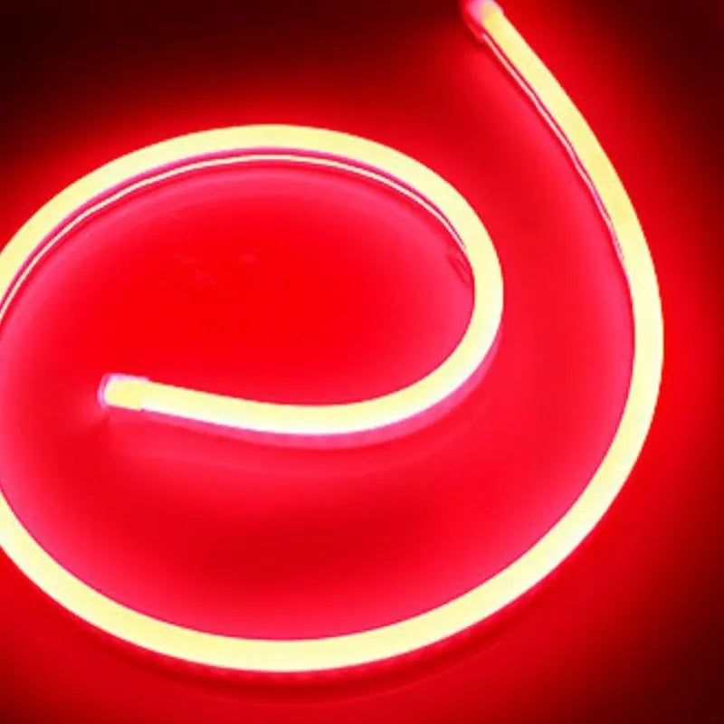 Close-up of flexible blue silicone LED neon strip showing dense LED beads, coiled on a 100-metre reel.