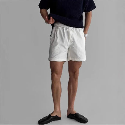 Men's loose-fit cotton sports shorts in black, shown on a hanger